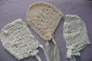 A trio of hand-crafted baby bonnets.