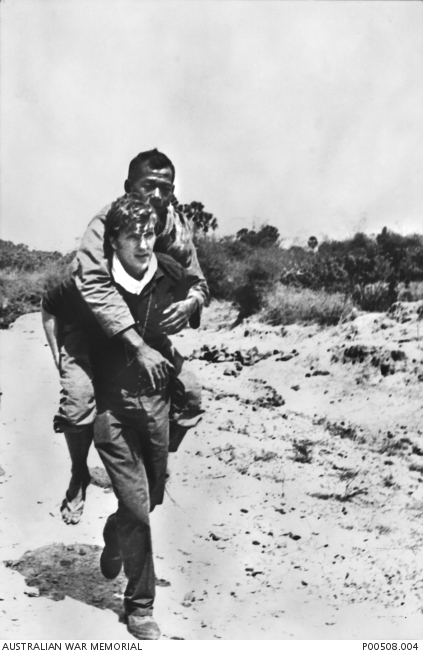 Phnom Penh, Cambodia, 1971. Australian cameraman Neil Davis carrying a wounded Cambodian soldier out of action. http://trove.nla.gov.au/work/165129872 Copyright unknown.