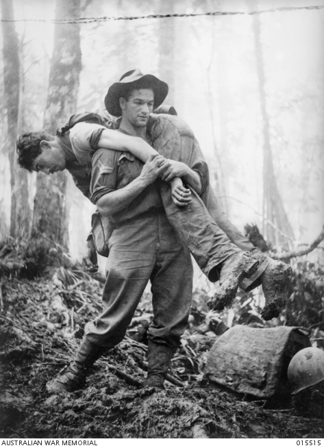 30 July 1943, Corporal Leslie (Bull) Allen MM, aged 26 of Ballarat, Victoria, carrying out an injured American soldier, one of 12 he retrieved. He was awarded the US Silver Star and had already received his Military Medal (MM) on 7 February 1943, at Crystal Creek, Wau. Negative by G Short, copyright expired. Mt Tambo, New Guinea. AWM image 015515