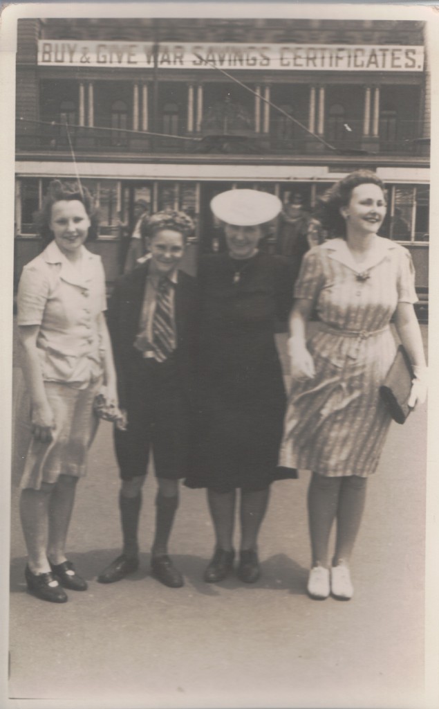 The Sydney siblings, Nora, Kevin and Marie with their aunty Nellie (in the hat).  I like the war bonds notice on the building.